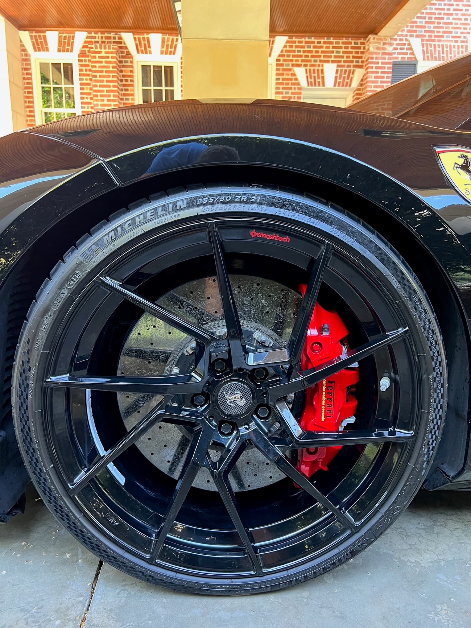 A clean Ferrari wheel face with a red caliper